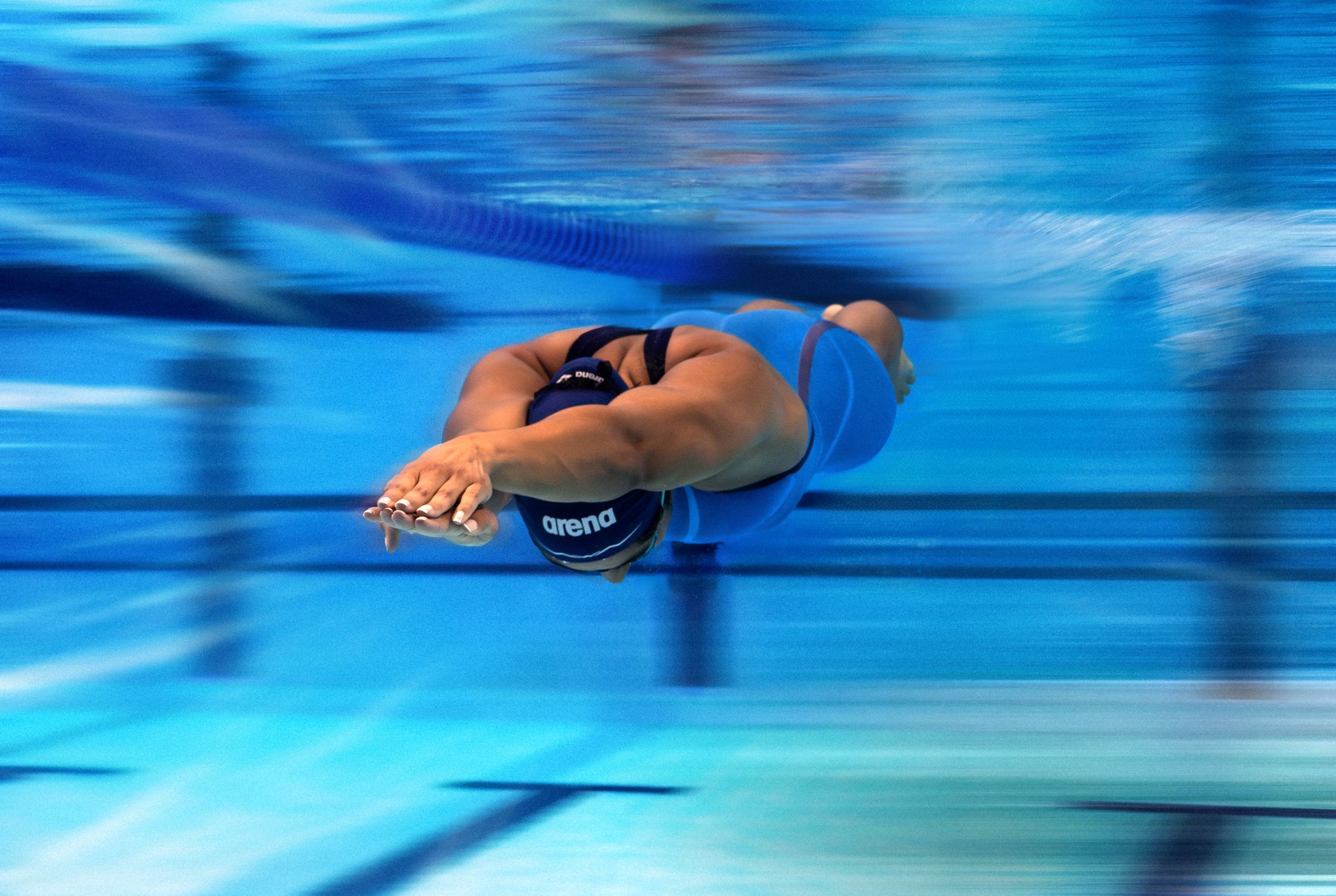 Swimmer gliding underwater at full speed in the Arena Powerskin AIR3 racing suit